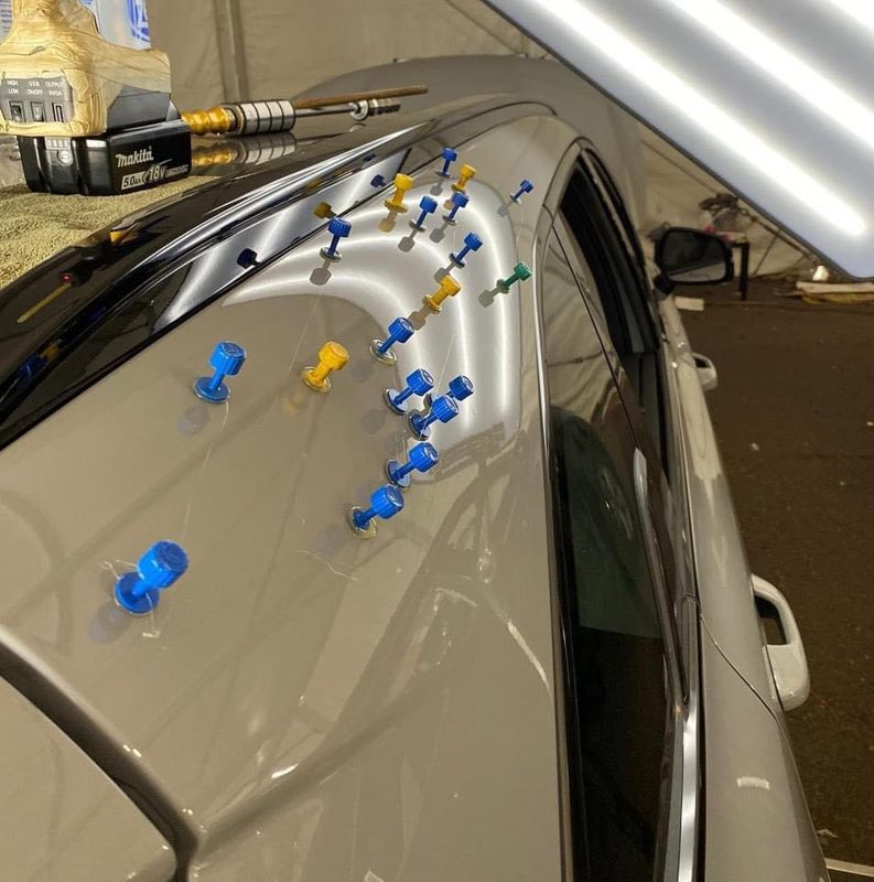 Sacabollos con tabs de pegado sobre el techo de un auto