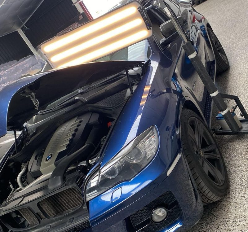 Auto azul con luz de línea en el taller